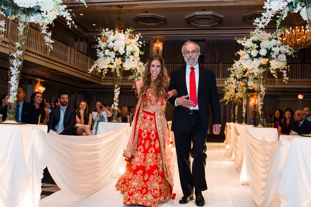 Bride and father walk down the aisle during an Indian wedding at The Drake Hotel in Chicago