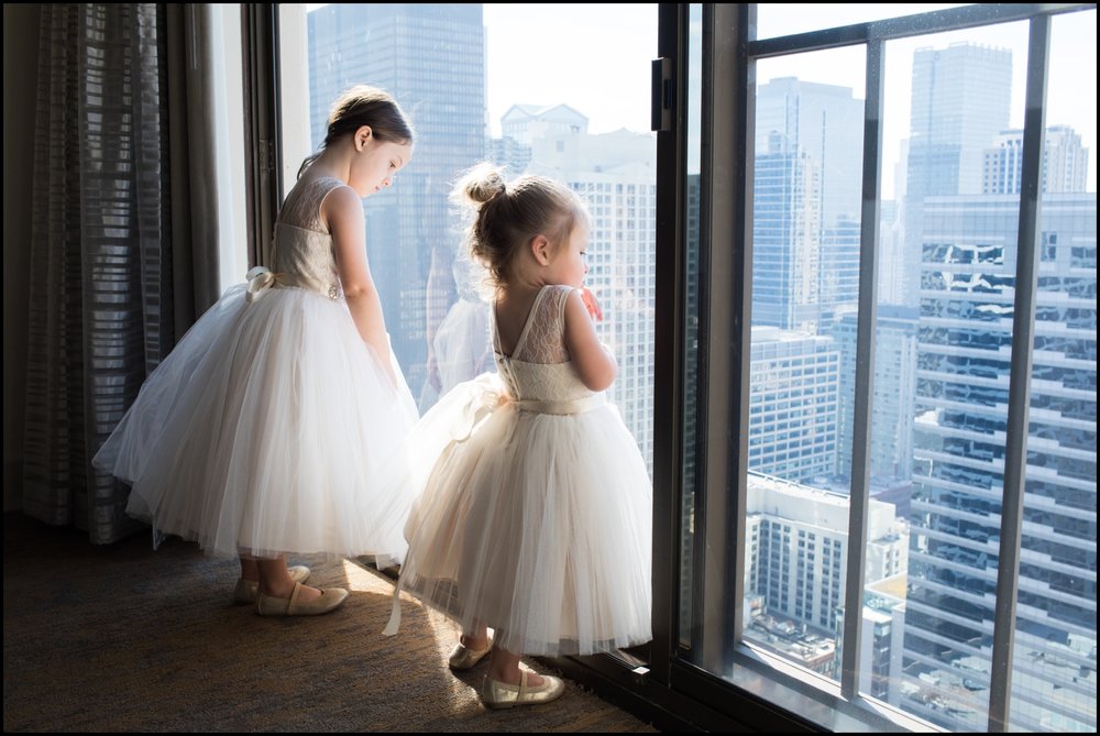  little girls looking at the window before a wedding 