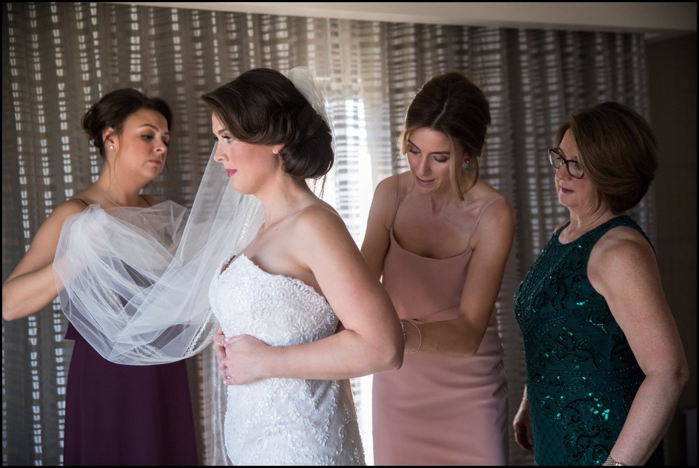  bridesmaids helping the bride get ready  