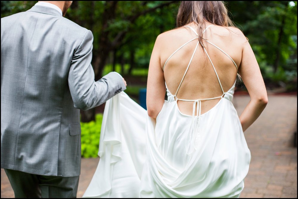  groom holding the bride’s dress 