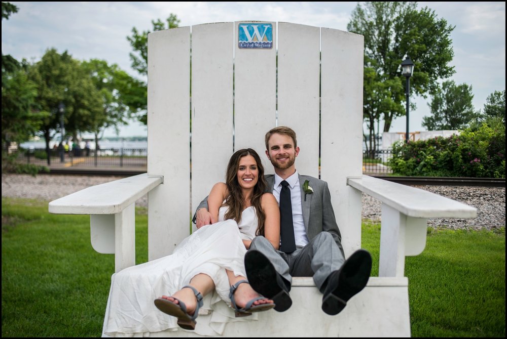  bride and groom sitting on a big chair 