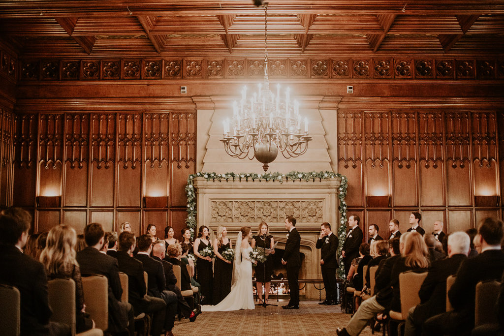 Wedding ceremony in front of fireplace at University Club Chicago wedding venue
