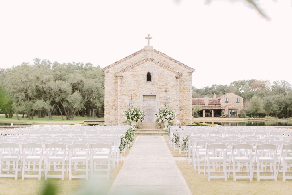 Wedding ceremony in front of 15th Century French Chapel at The Clubs at Houston Oaks 
