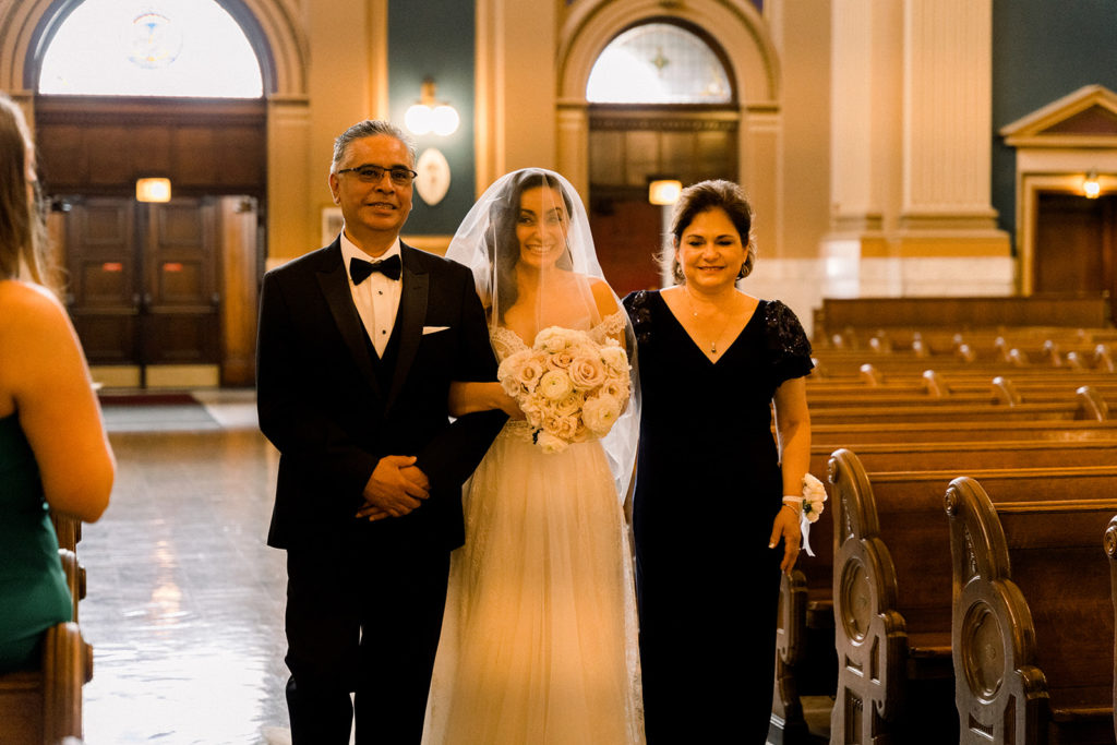 Bride and parents walking down the aisle