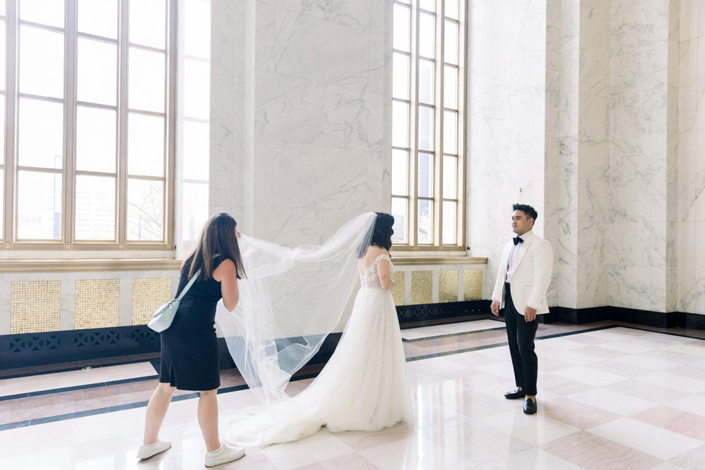 Women holding veil for bride in the historic lobby at The Old Post Office Chicago wedding venue