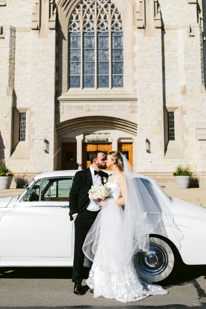 Bride and groom kissing in front of church