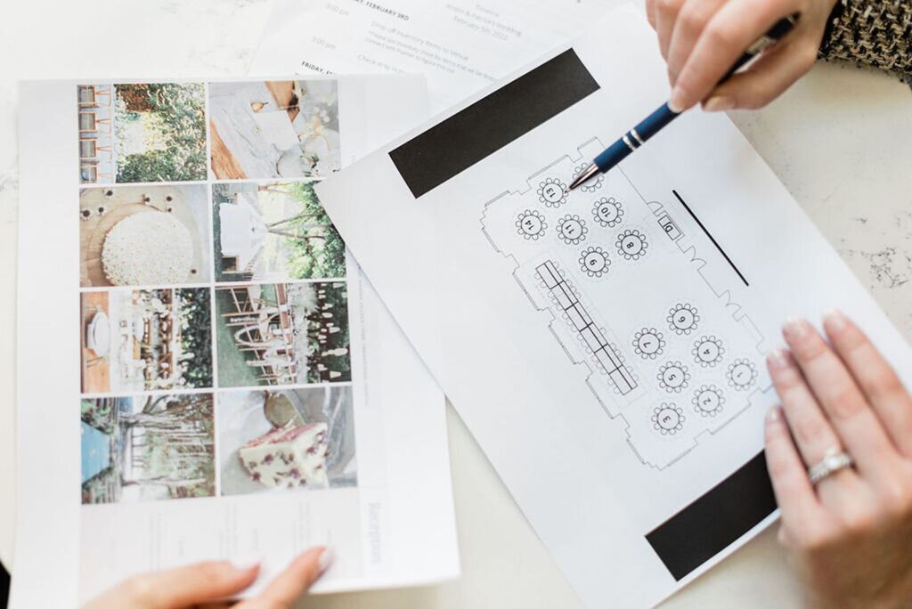Wedding planner reviewing seating chart with couple for wedding reception