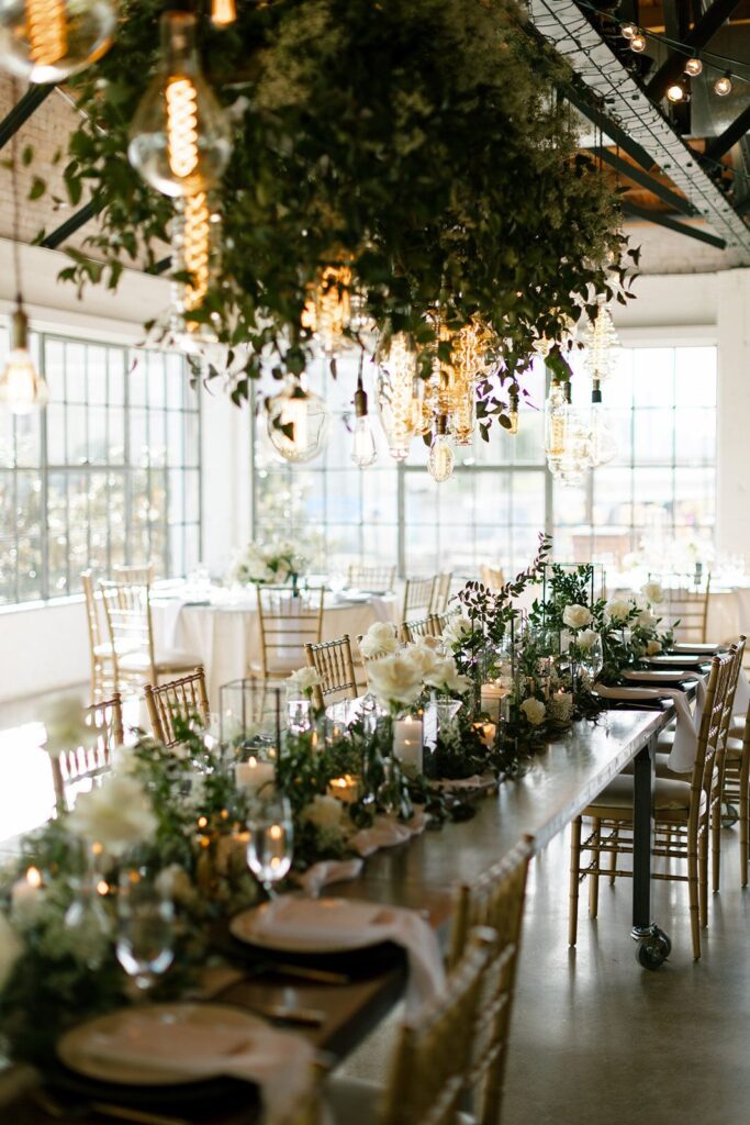 Dallas wedding reception with greenery-covered chandeliers and tablescape