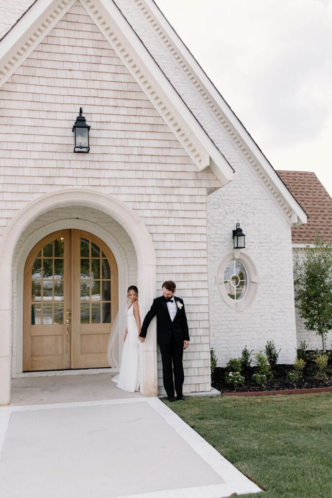 bride and groom holding hands outside the chapel