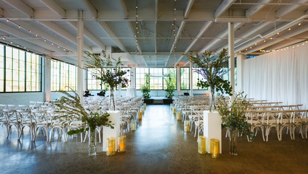 Indoor wedding ceremony at The Whim flanked with greenery