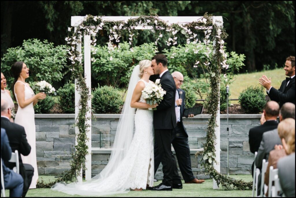 First kiss for bride and groom at courtyard wedding ceremony