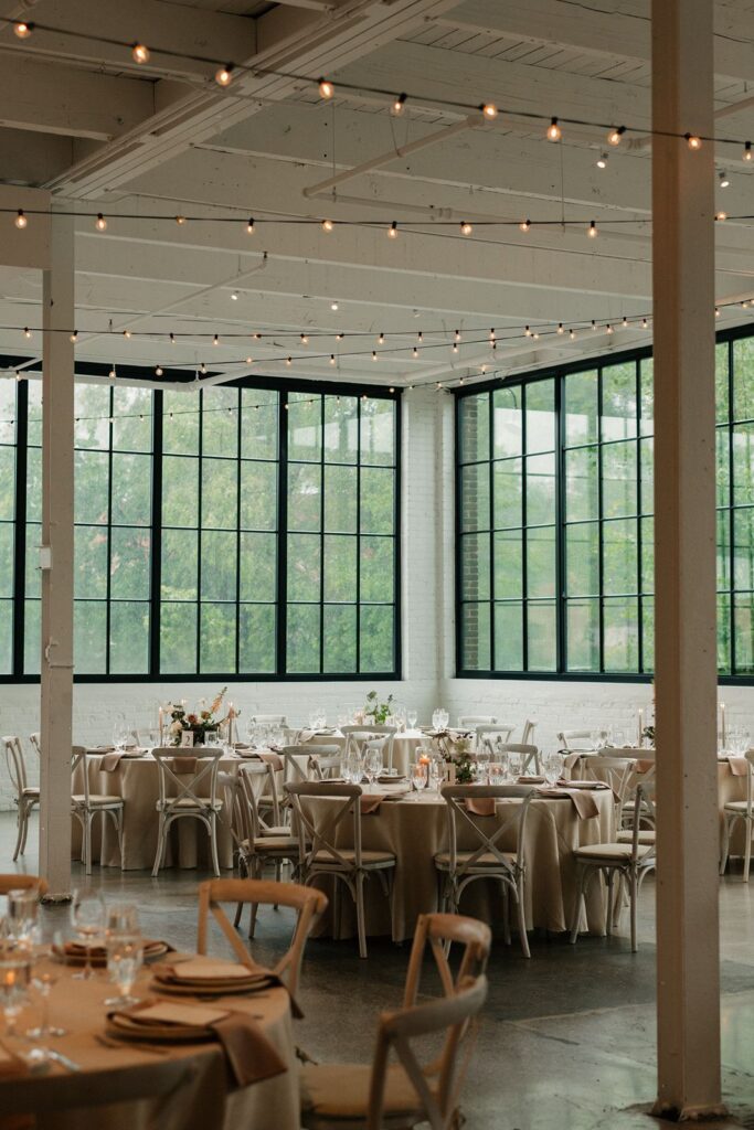 Indoor wedding reception under bistro lights