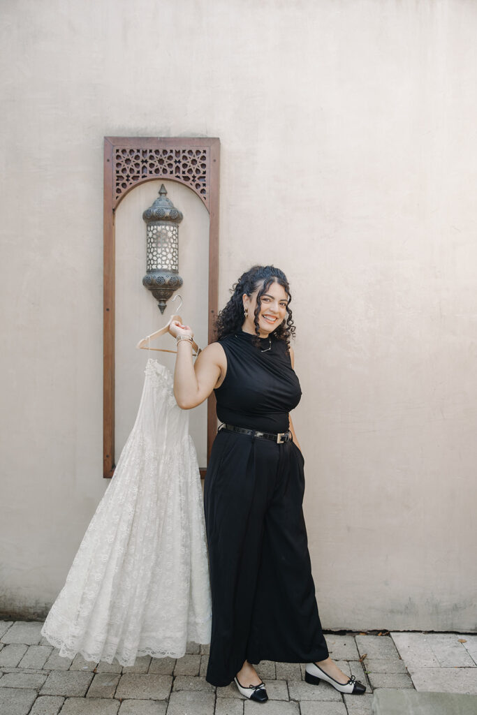 wedding planner holding a bridal gown