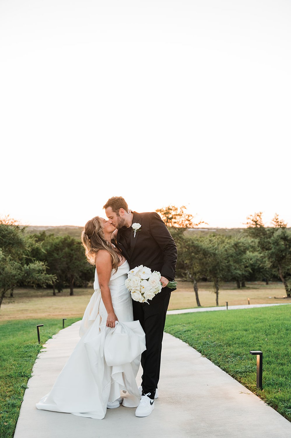 Bride and groom kissing with Hill Country views